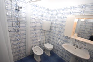 A bathroom with a patterned tile design, a shower, a bidet, a toilet, and a sink. - Residence La Meridiana (Lignano Sabbiadoro)