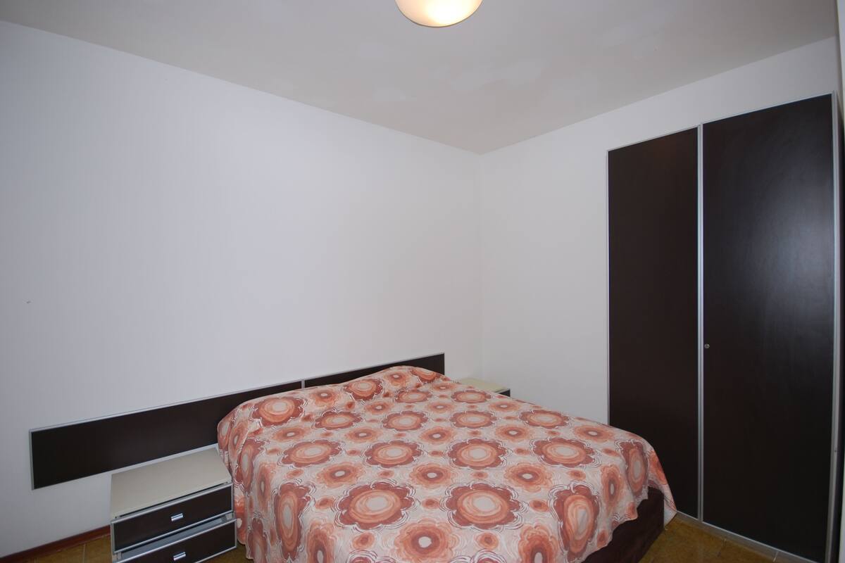 Ein Schlafzimmer mit einem Bett, einem Kleiderschrank und einem Nachttisch.