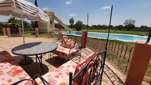 Un espace extérieur aménagé avec une piscine, du mobilier de jardin et un toboggan.