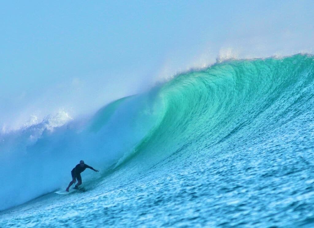 A surfer riding a large wave.