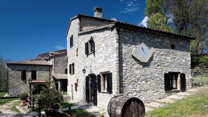 A stone building with a large barrel and a wooden fence.