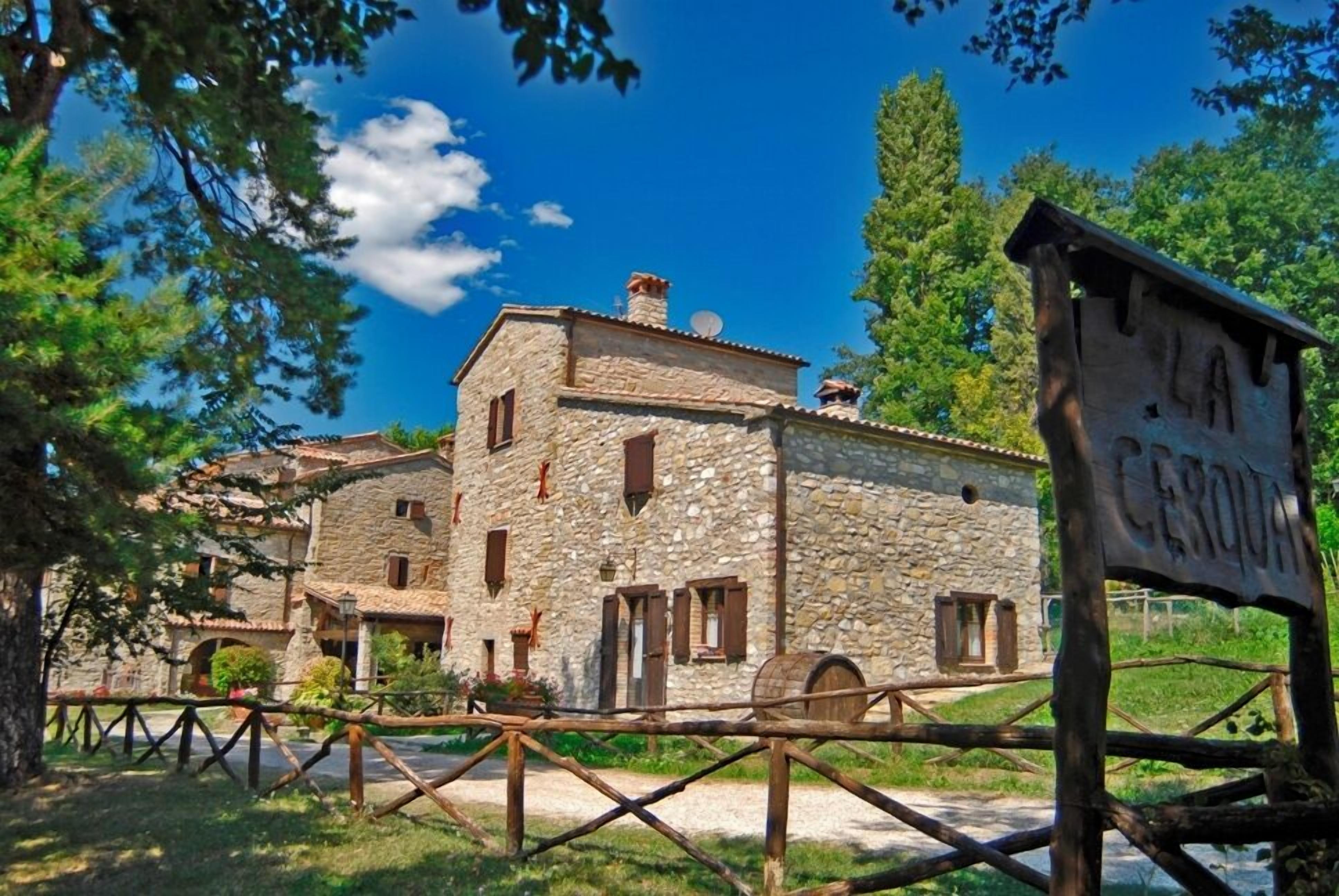A stone building with multiple windows and a sign that reads 'LA CERVA.'
