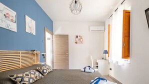 A modern bedroom with a bed, pillows, a desk, and a chair. - B&B Home Visit (Agrigento)