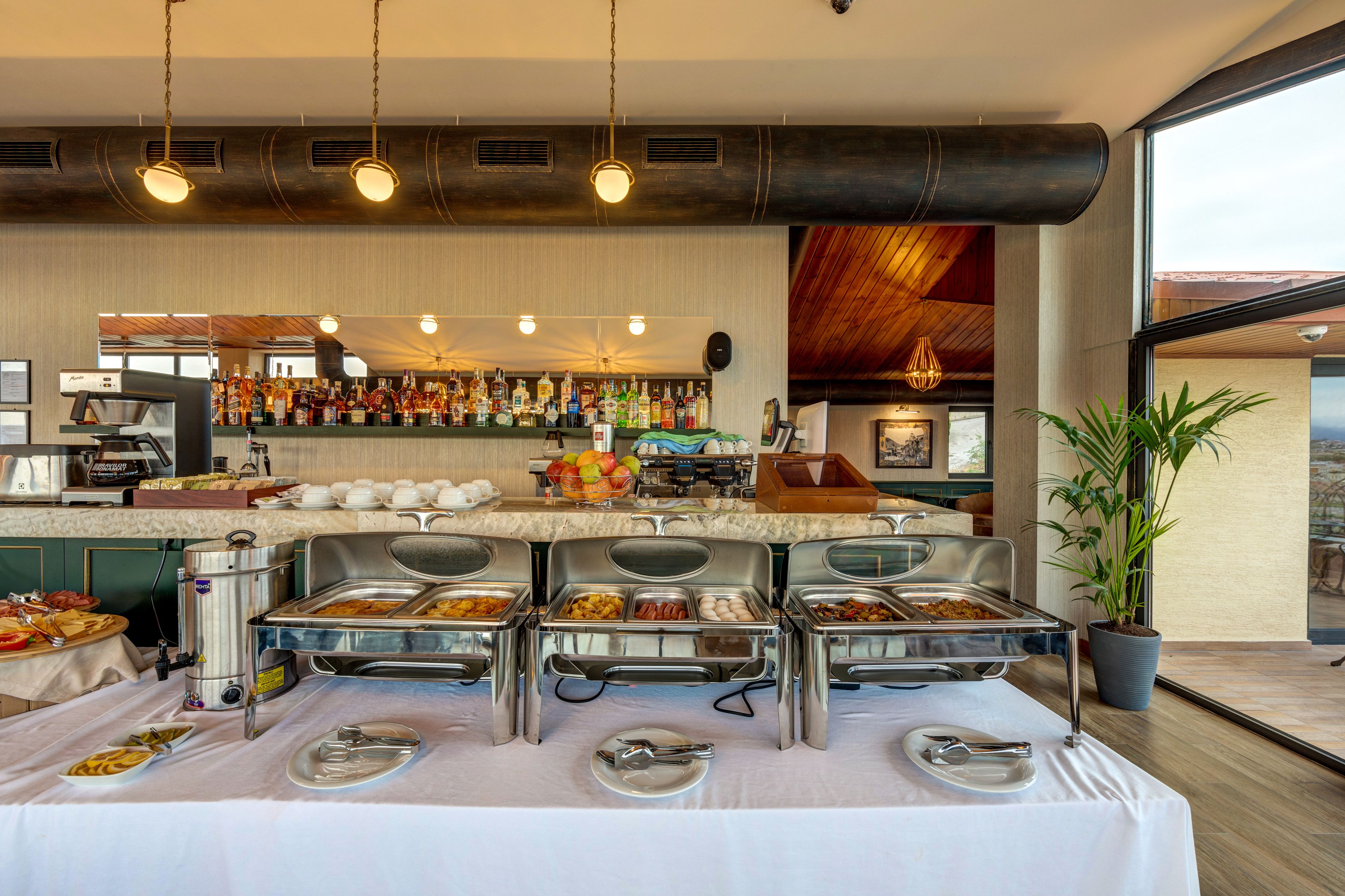 A buffet setup with various food items and a coffee station.