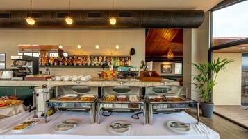 A buffet setup with various food items and a coffee station.