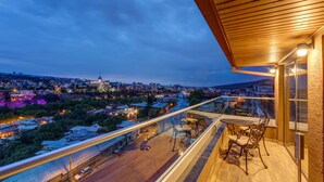 A balcony with a glass railing overlooking a cityscape at dusk. - Sole Palace (Tbilisi)