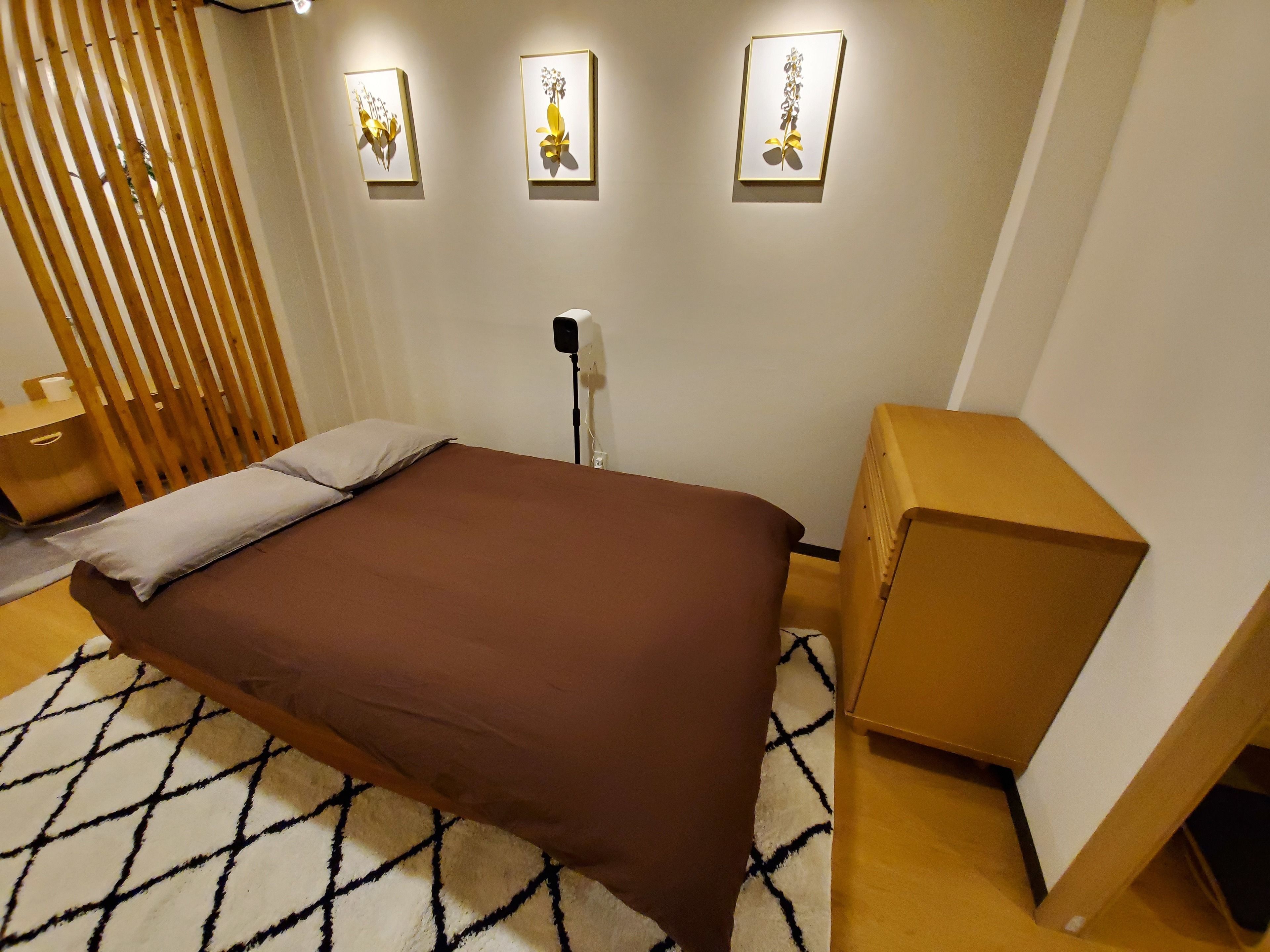A neatly arranged bedroom with a bed, bedside table, and a small wooden cabinet.