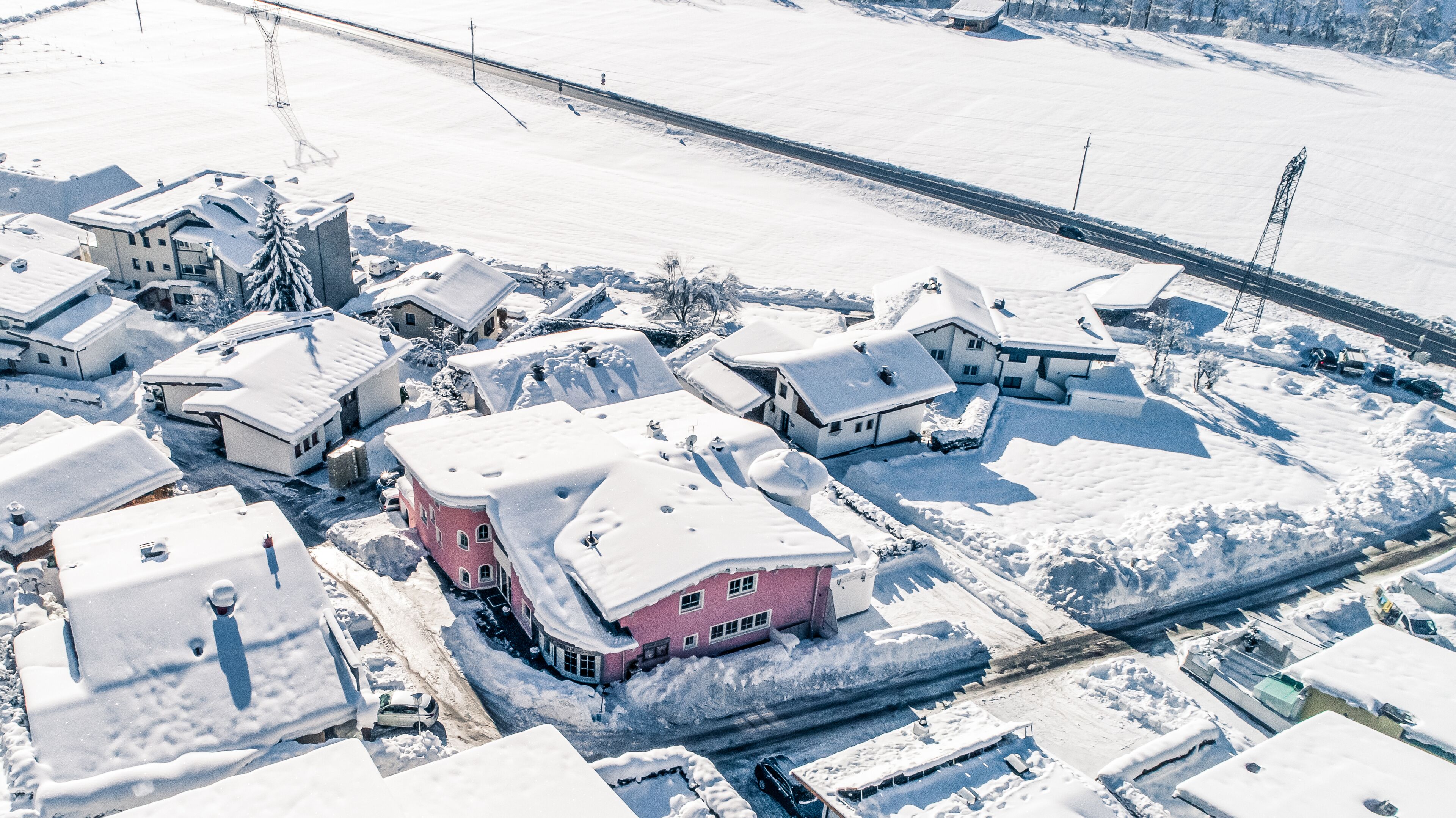 Ein Wohngebiet mit schneebedeckten Häusern und einer Straße.