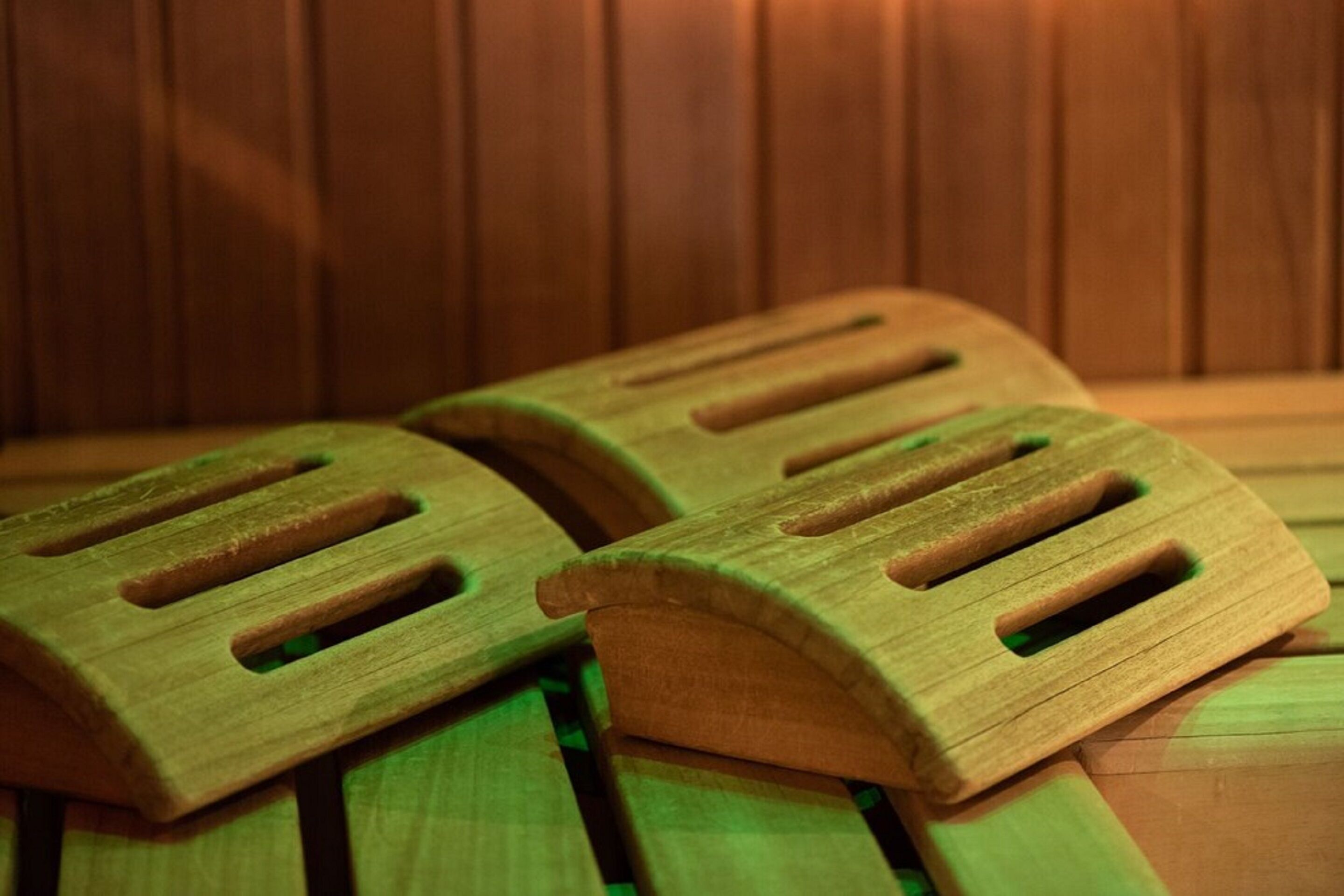 Zwei Holzfußstützen mit ausgeschnittenen Vertiefungen auf einer Holzbodenfläche.