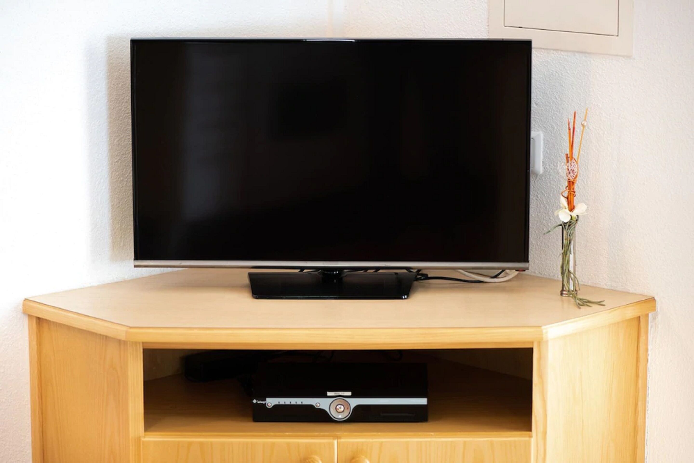 A flat-screen TV on a wooden TV stand with a DVD player below.