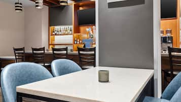 A restaurant with a bar area, seating, and a Starbucks logo on the wall.