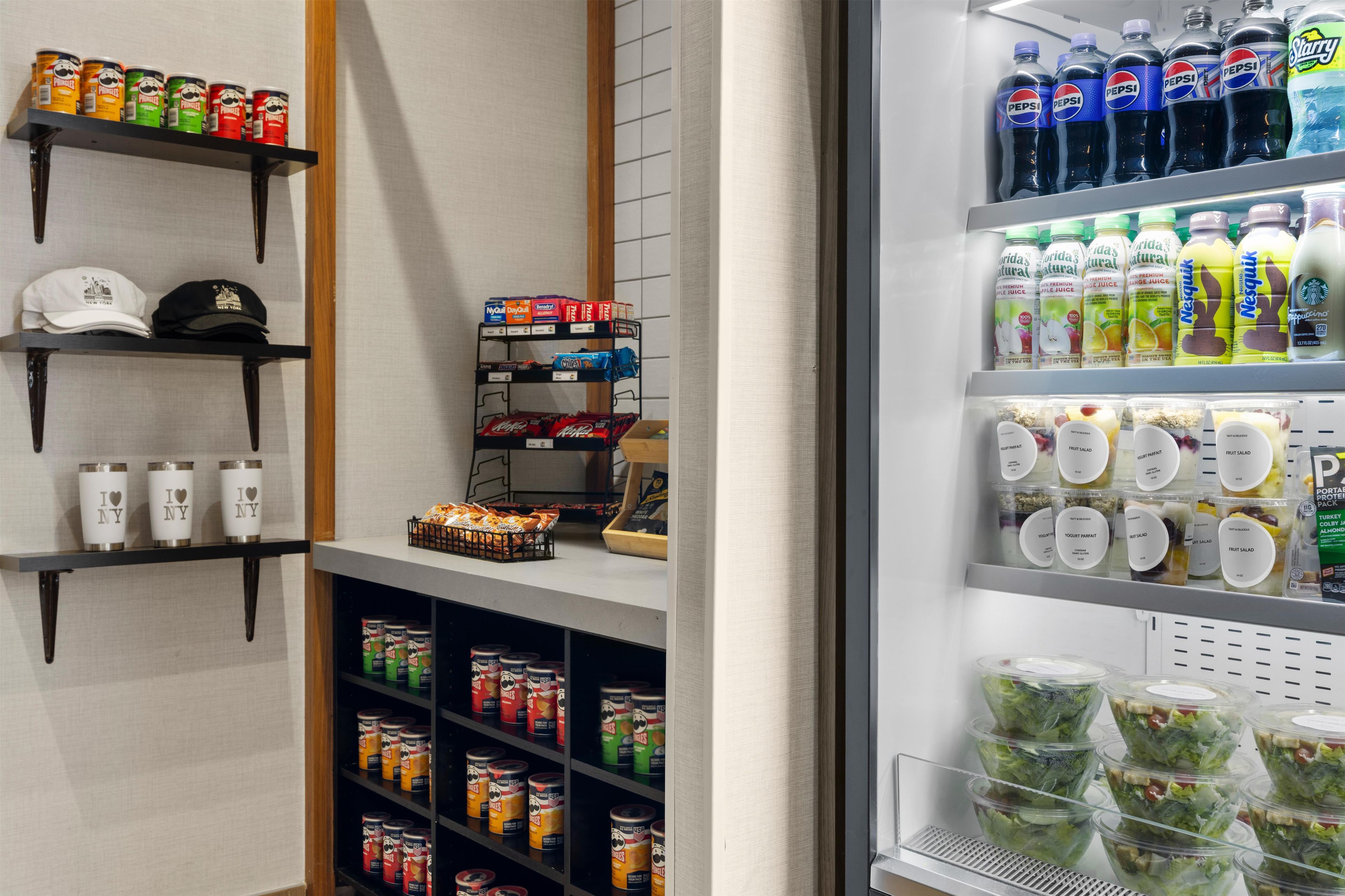 A refrigerated display with various beverages, snacks, and bottled water.
