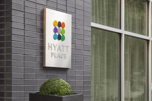 A sign for 'HYATT PLACE' with a color palette graphic and a neatly trimmed hedge in front. - Hyatt Place New York City/Times Square (New York)