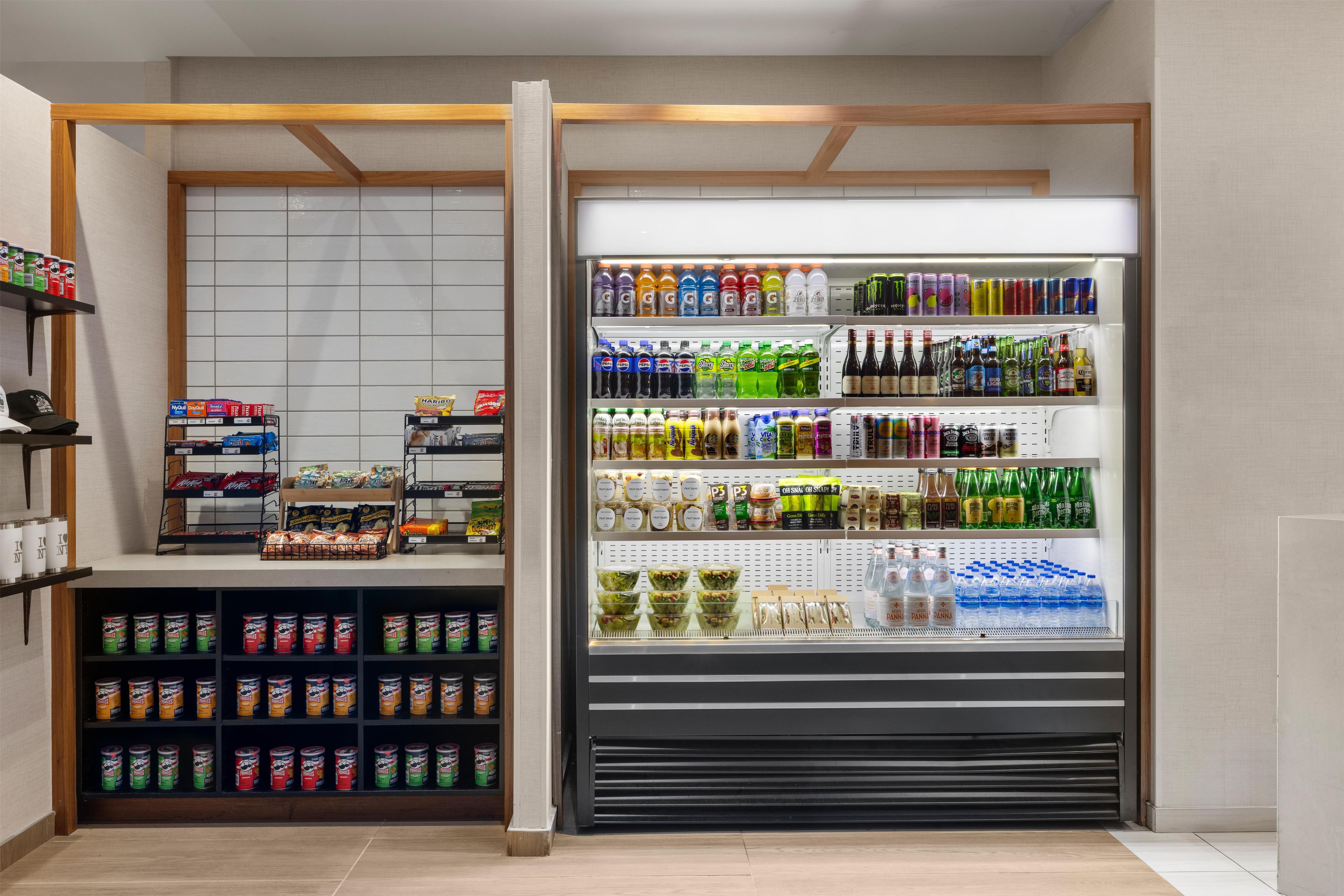 Mostrador refrigerado con diferentes bebidas y aperitivos.