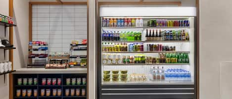 Mostrador refrigerado con diferentes bebidas y aperitivos.