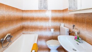 Une salle de bain avec une baignoire, des toilettes et un lavabo.