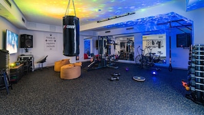 Een sportschool met een bokszak, trainingsapparatuur en een motiverende quote op de muur.