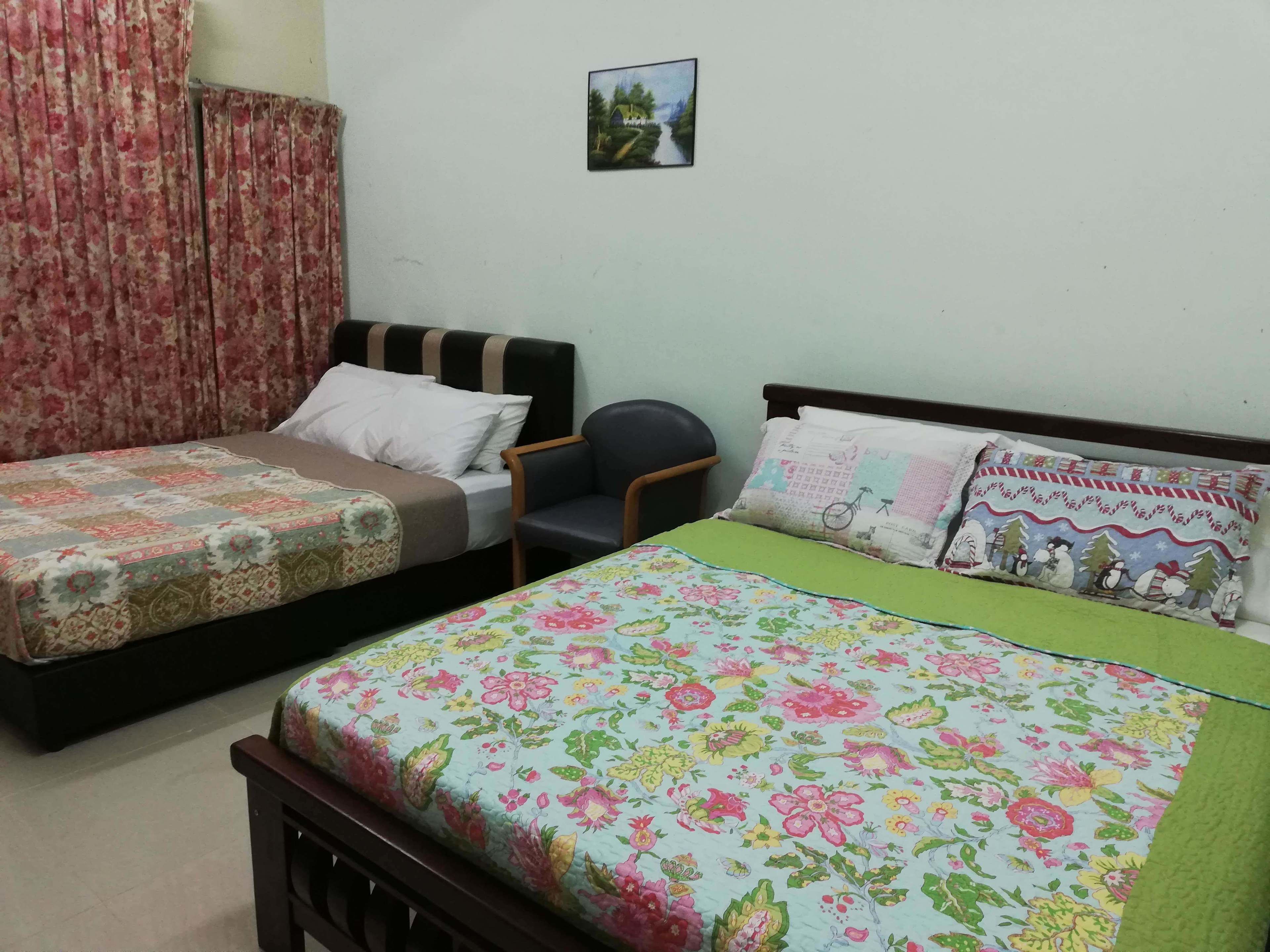 A bedroom with two single beds, a chair, and a small picture on the wall.