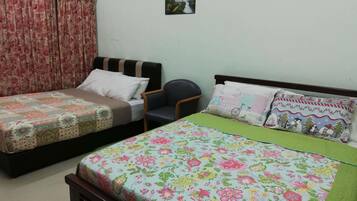 A bedroom with two single beds, a chair, and a small picture on the wall.