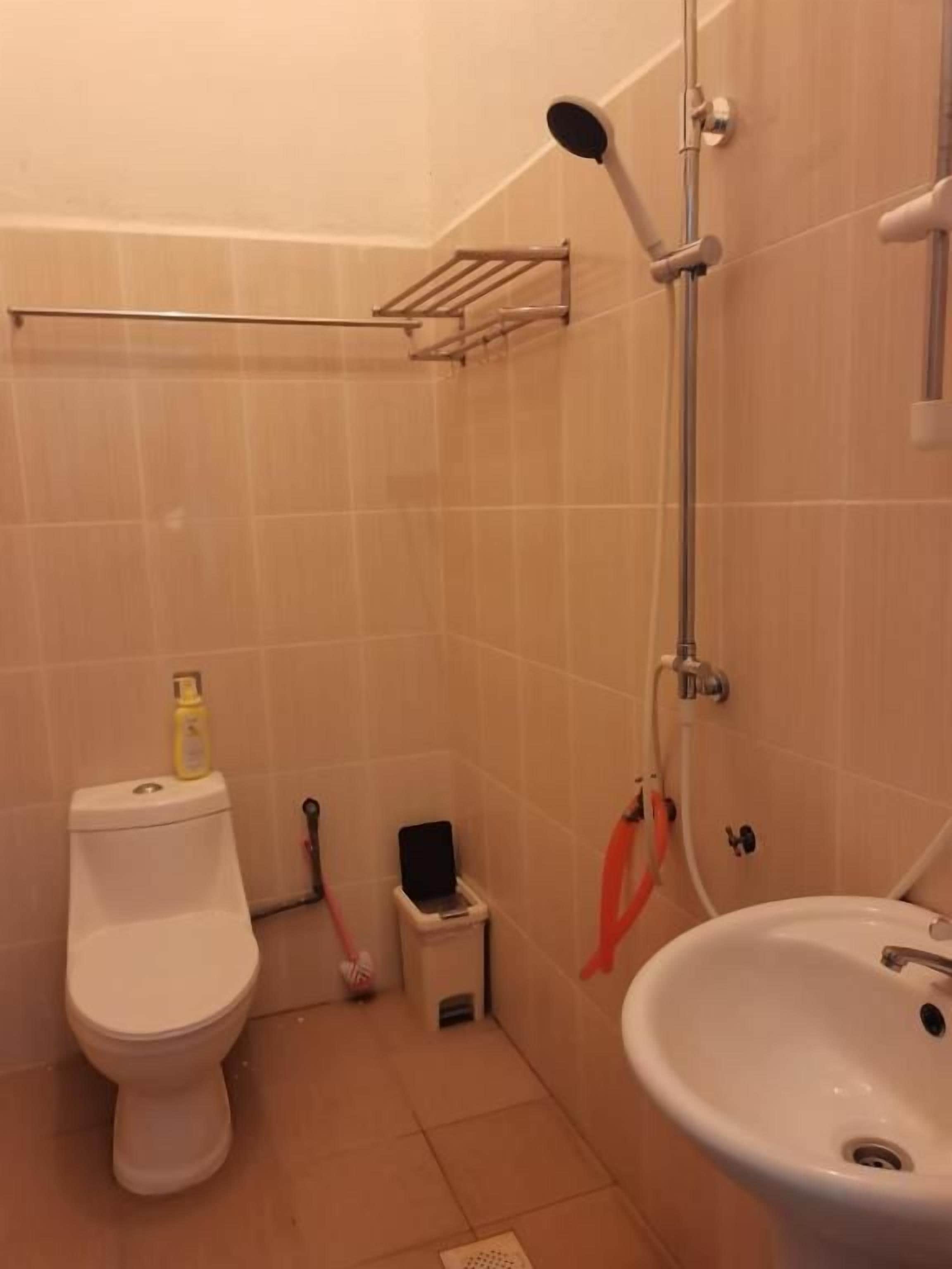 A bathroom with a toilet, sink, and shower.