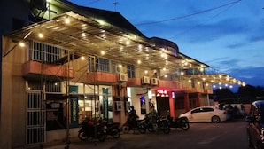 A building with multiple floors, a covered entrance, and several motorcycles parked in front.