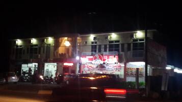 A building with multiple illuminated signs, including a prominent Coca-Cola sign.
