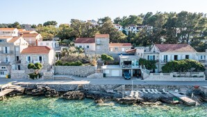 Una località costiera con edifici in pietra, acque cristalline e un litorale roccioso.