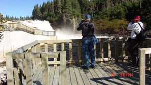 A wooden deck overlooking a waterfall with a metal railing. - Torrent River Inn (Hawke's Bay)