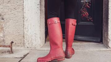 Ein Paar rote Gummistiefel auf einer Betonfläche.