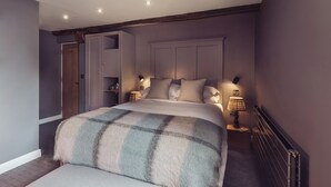 A bedroom with a large bed, a wardrobe, and bedside lamps. - The New Inn - Yealand (Carnforth)