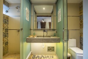 A bathroom with a glass-enclosed shower, a sink with a towel rack, and a toilet. - Bananas Adventure Hostel (Ica)