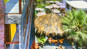 A resort with a pool, outdoor seating, and a view of the desert. - Bananas Adventure Hostel (Ica)