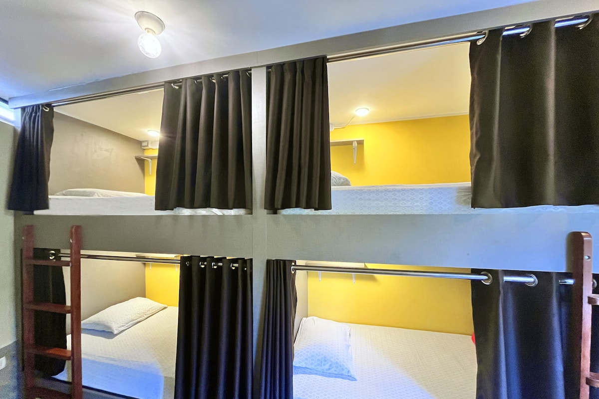 Habitación con literas, cortinas y pared amarilla.