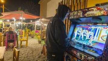 A person playing a video game at an outdoor arcade.