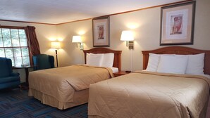 A hotel room with two beds, a desk, a chair, and a window with curtains. - Franconia Notch Motel (Lincoln)