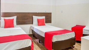 A hotel room with three single beds, each with a red blanket and pillow. The room has a wooden headboard and white walls. - HOTEL PAULISTANO Center Norte (São Paulo)