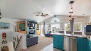 A modern kitchen with teal cabinets, a dishwasher, and a ceiling fan. - Sound Waves - Colington Harbor, Waterfront, Pets OK, Community Pool & Soundfront Beach (Kill Devil Hills)