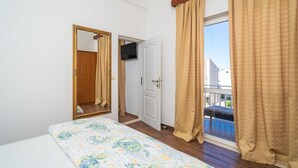 A bedroom with a bed, a mirror, a door, and a window with curtains. - Apartments Senjo - One Bedroom Apartment with Balcony and Sea View (4 adults) (Cavtat)
