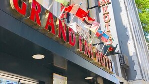 The exterior of the Grand Hotel with multiple flags displayed prominently. - Grand FM Hotel (Istanbul)