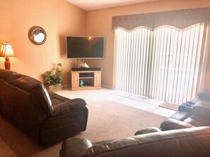 Relax in this cozy living space with a large flat-screen TV and comfortable seating for two.