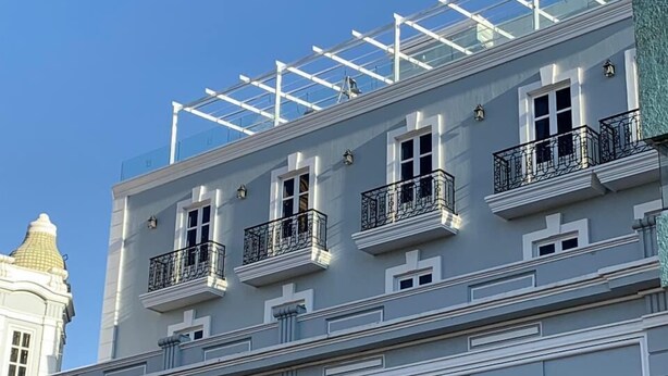 Un hôtel à la façade classique, doté de nombreux balcons et d’une enseigne indiquant qu’il s’agit d’un hôtel.