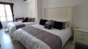 Une chambre d’hôtel avec deux lits, une table de chevet et une chaise.