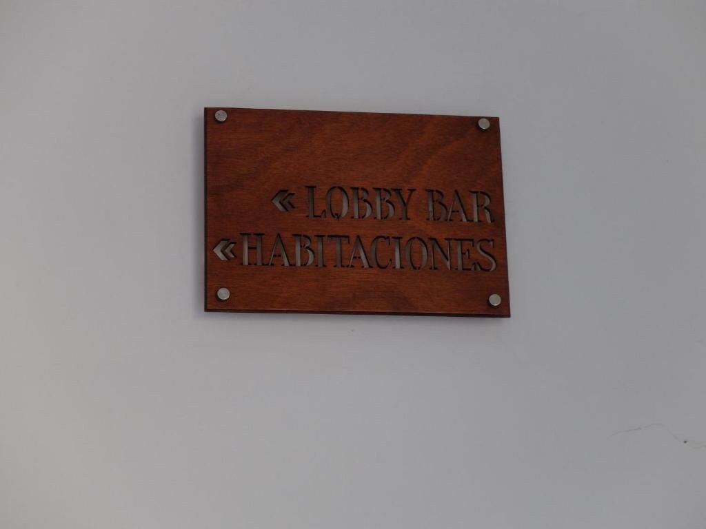 Señal de madera que indica 'Lobby Bar' y 'Habitaciones', mostrando la dirección al bar del vestíbulo y a las habitaciones.