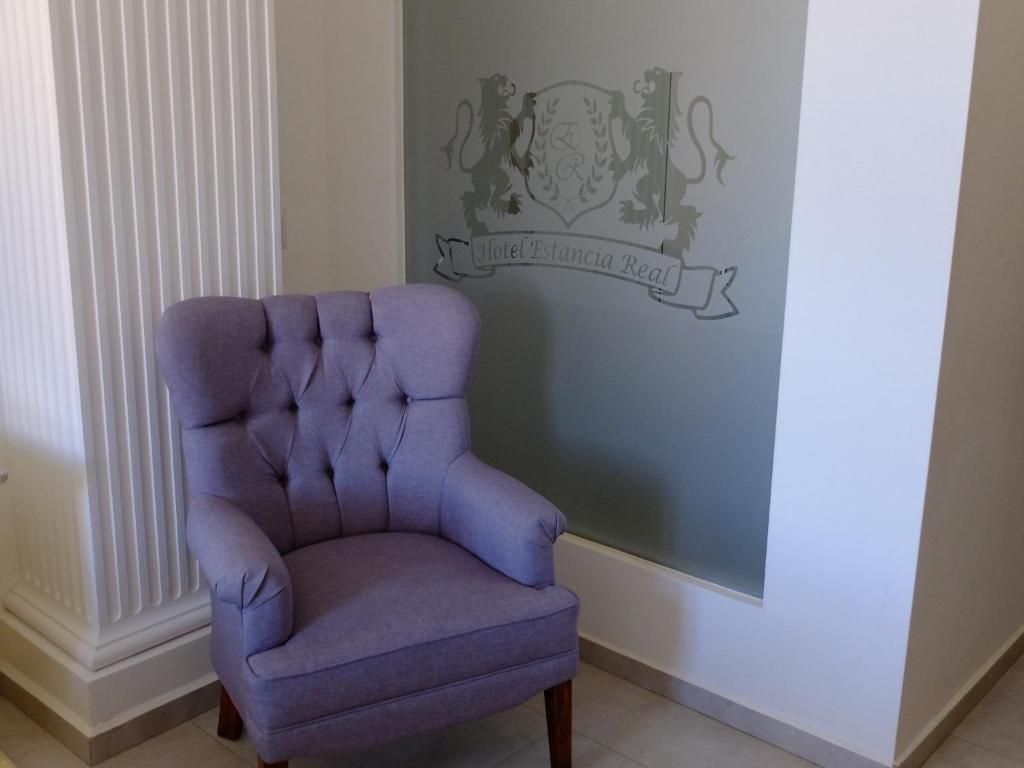 Un fauteuil capitonné placé dans un coin, avec un emblème fixé au mur juste au-dessus.