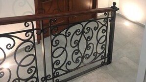 Une porte en bois avec une rambarde en métal devant.