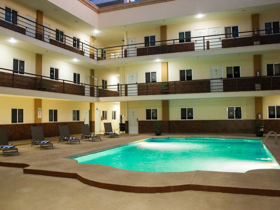 Una piscina al aire libre, sombrillas, tumbonas