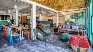 A spacious cafe with high ceilings, wicker furniture, and a vibrant interior design. - Selina Floripa (Florianópolis)