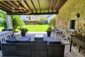 An outdoor patio with wicker furniture, a table, and a foosball table. - Holiday home Carmen (Llanes)