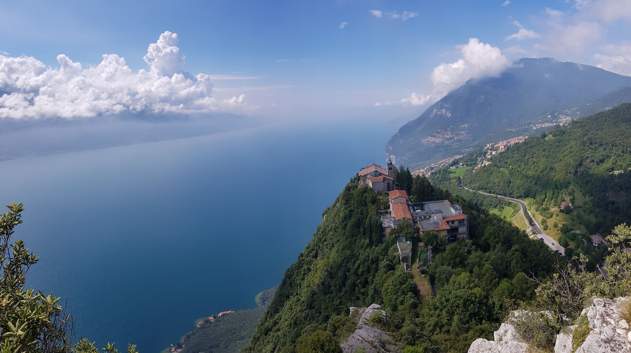 A coastal village with buildings on a hillside overlooking a calm sea.