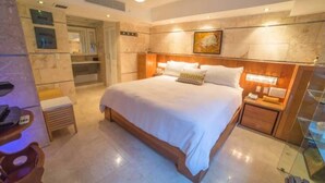 Un dormitorio espacioso con una cama grande, una mesita de noche y un armario empotrado.